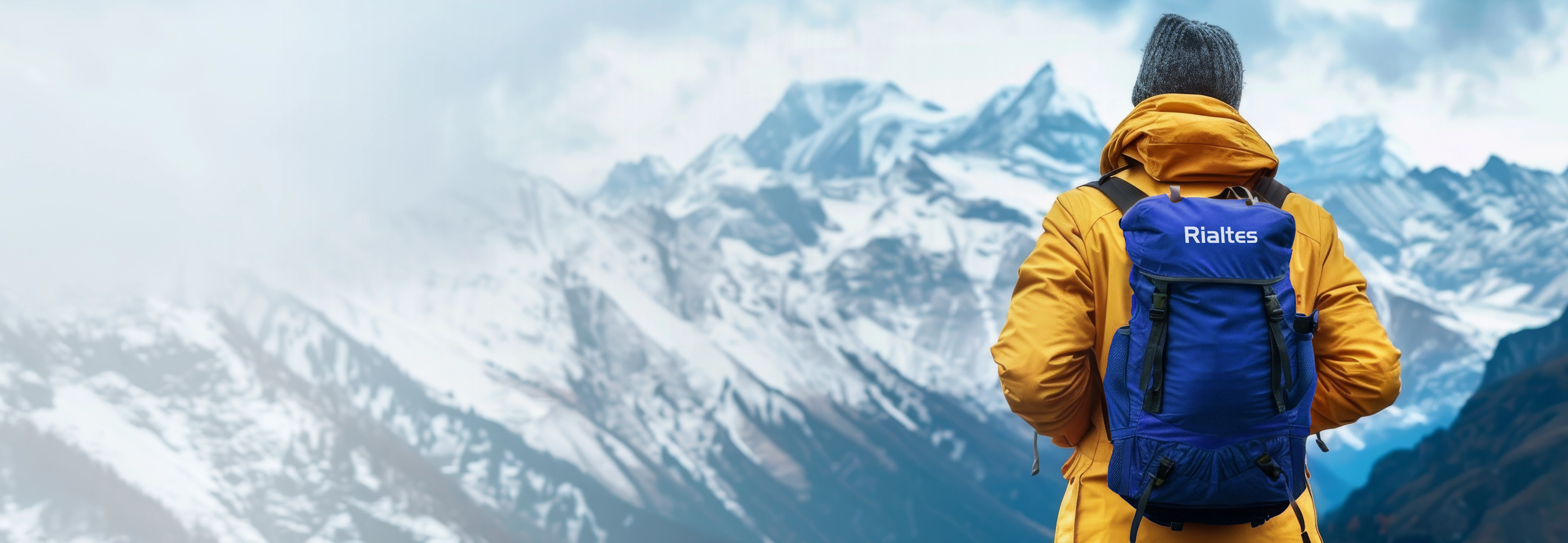 Hiker with Rialtes backpack facing snowy mountain peaks representing company culture values and daily growth mindset journey