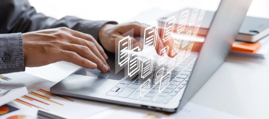 Hands typing on laptop with digital file icons overlay representing data management, document organization, and cloud storage