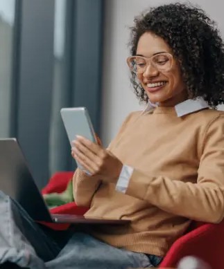 User working on laptop with phone displaying AgentChat AI tools