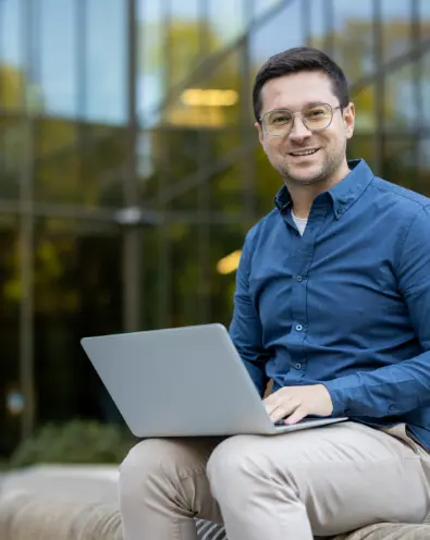 Smiling professional using laptop to access prebuilt AI business solutions